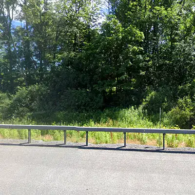 A side of the road with a barrier