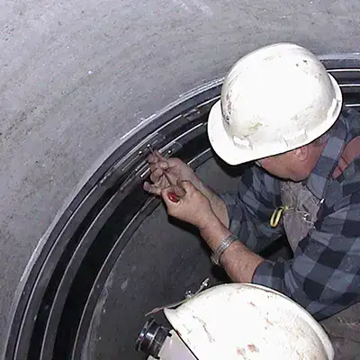 Technician installing HydraTite over a joint in a pipe