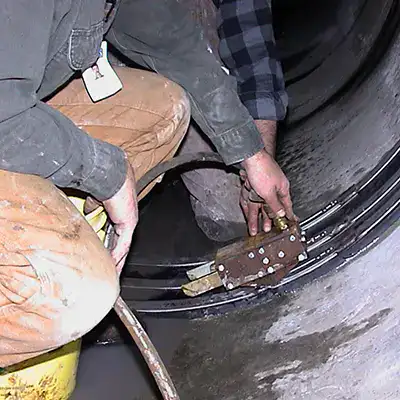 A hydraulic expander being used to expand the retaining bands of a HydraTite seal to lock the rubber in place over the repair