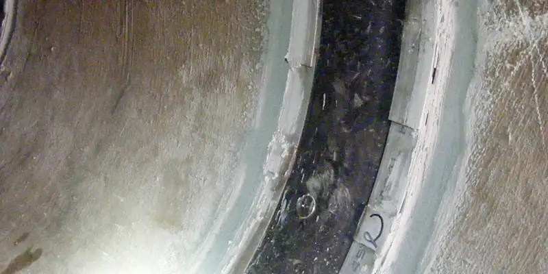 A HydraTite seal installed over a joint in a pipe with concrete rounding out the lip of the seal