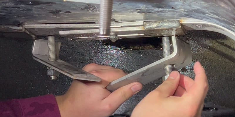 A technician adjusting hold-downs