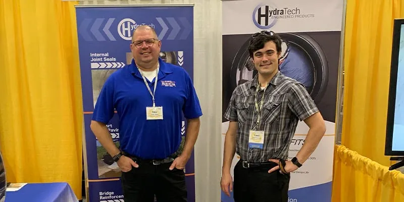 Two people standing in a HydraTech booth