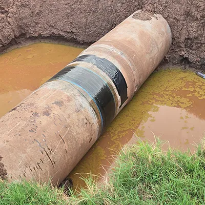 HydraWrap applied to the exterior of a partially unearthed pipe