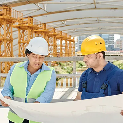 Two people looking over construction plans at a project site